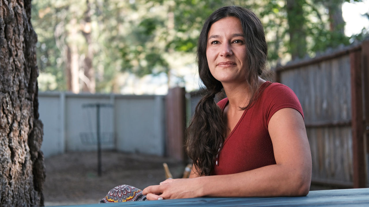 side shot a woman sitting down and smiling